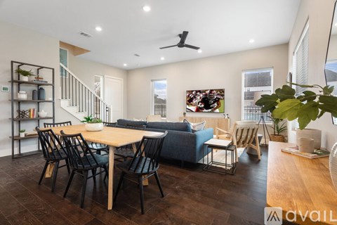 A modern living room with a dining table and chairs.