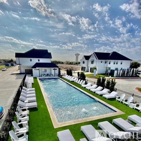 A large outdoor swimming pool surrounded by sun loungers.