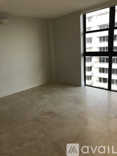 A room with a large window and a view of a building outside.