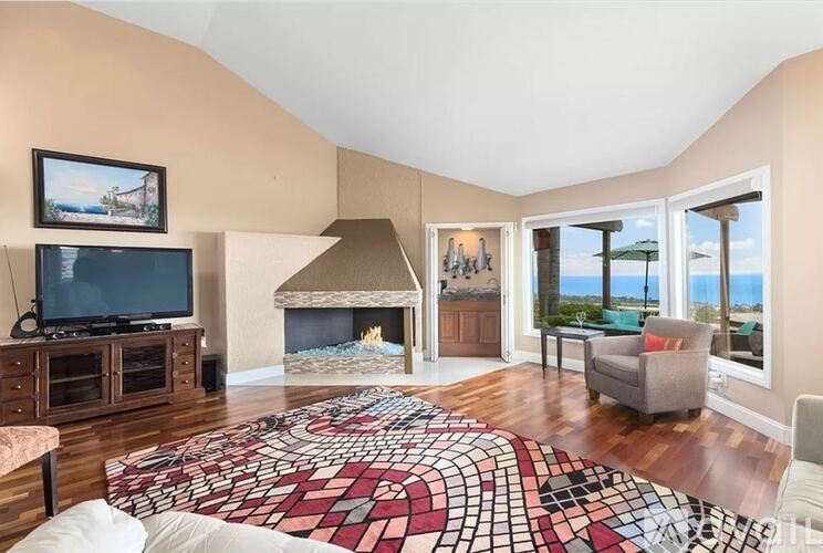 A living room with a fireplace and a television.