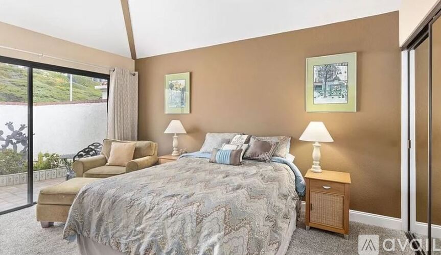 A bedroom with a large bed and a balcony.