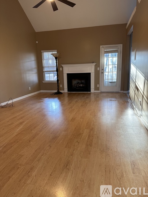 A living room with a fireplace and a ceiling fan.