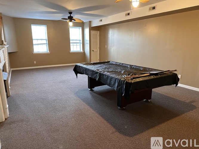 A bedroom with a bed, carpet, and a ceiling fan.