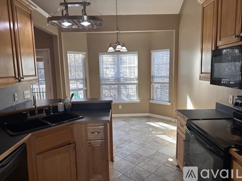 A kitchen with wooden cabinets and black countertops.