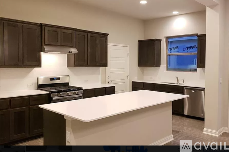 A kitchen with brown cabinets and a white island.