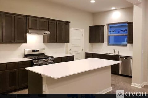 A kitchen with brown cabinets and a white island.