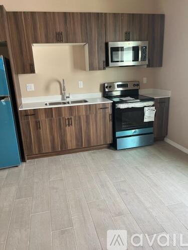 A kitchen with wooden cabinets and a blue fridge.