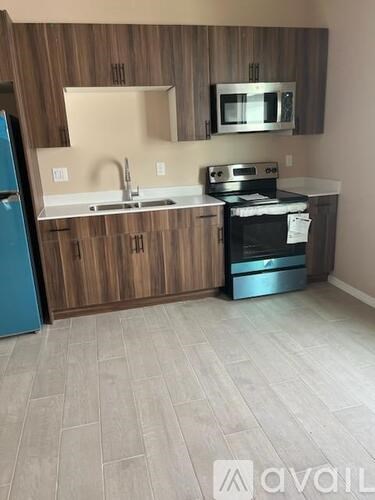 A kitchen with wooden cabinets and a blue fridge.