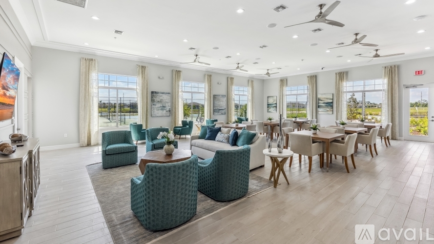 A spacious living room with a variety of seating options and a view of the outdoors through large windows.