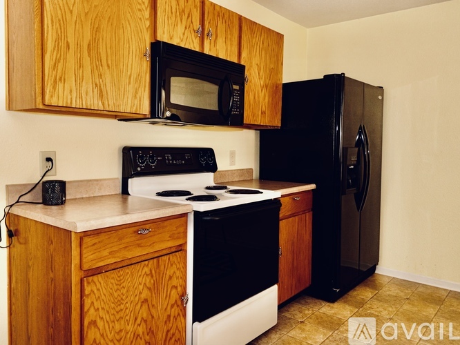 A kitchen with wooden cabinets and black appliances.