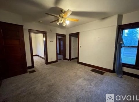 A room with a ceiling fan and carpeted floor.