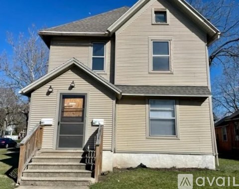 A house with a grey facade and a brown door.
