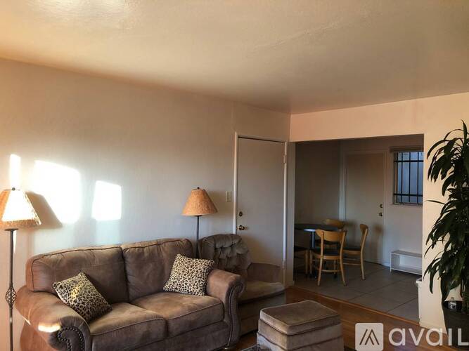 A living room with a brown couch and two lamps.