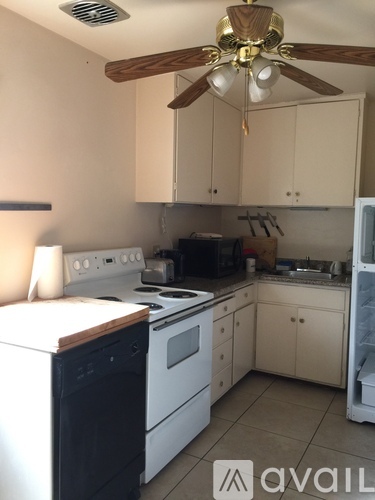 A kitchen with a white stove and a fan.