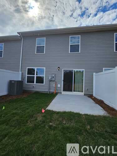 A grey house with a white fence and a small yard.