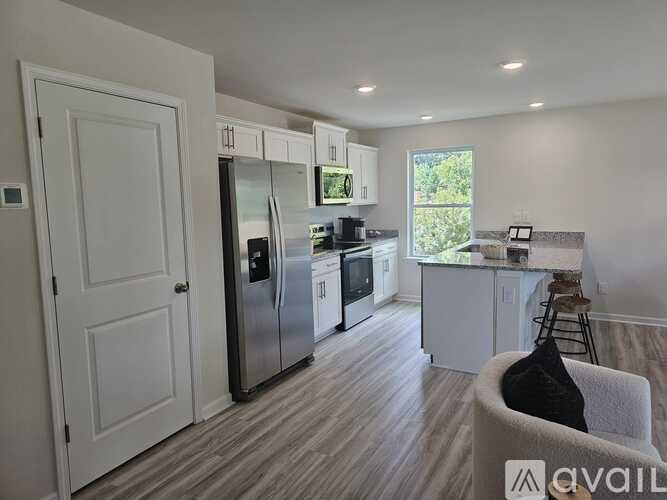 A kitchen with a refrigerator, oven, and microwave.