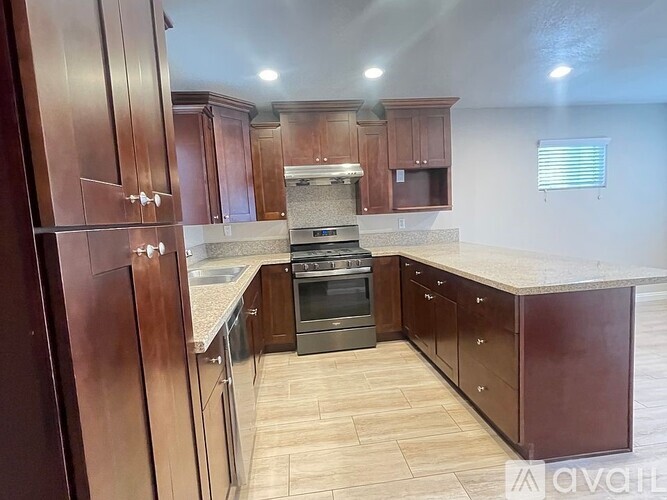 A kitchen with wooden cabinets and a stainless steel oven.