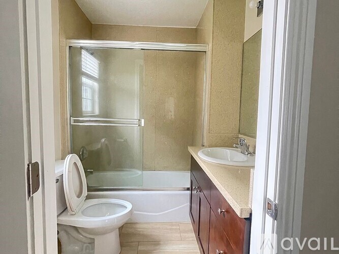 A bathroom with a toilet, sink, and shower.