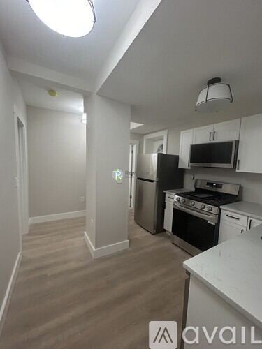 A kitchen with white cabinets and a black stove top oven.