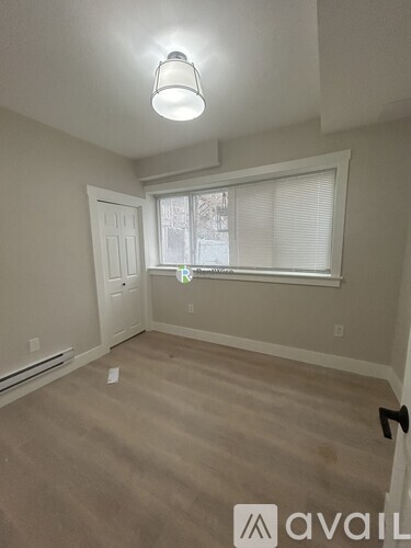 A room with a window and a door is available for rent.