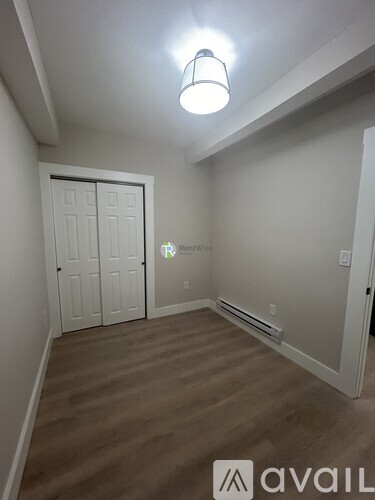 A room with a white door and a light on the ceiling.