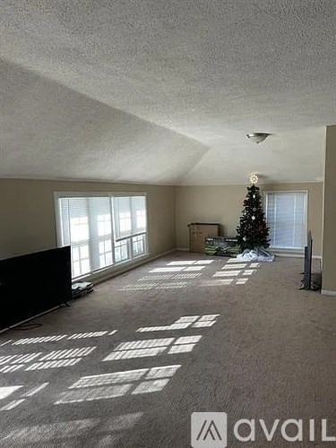 A living room with a Christmas tree and a carpet with white squares on it.