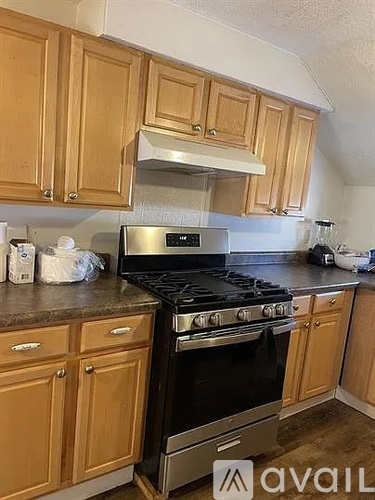 A kitchen with wooden cabinets and a stainless steel stove.
