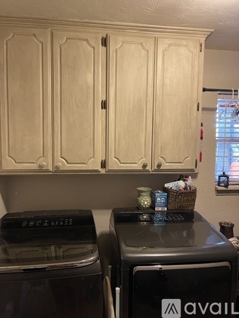 A kitchen with wooden cabinets and two black dishwashers.
