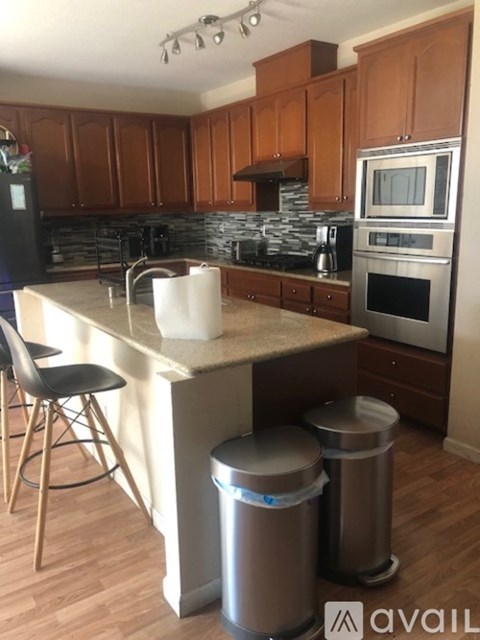A kitchen with wooden cabinets and a granite countertop.