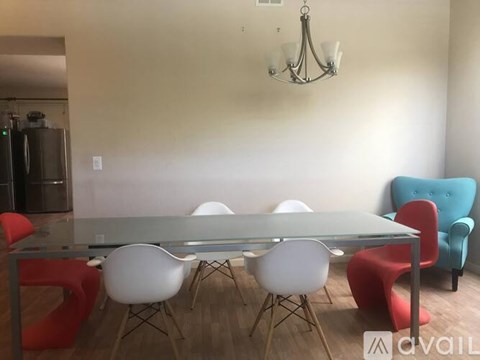 A modern dining room with a glass table and chairs.