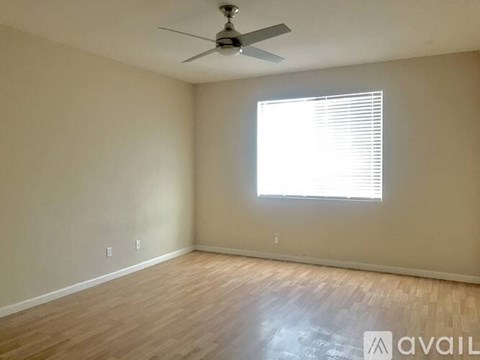 A room with a bed, a chair, and a ceiling fan.