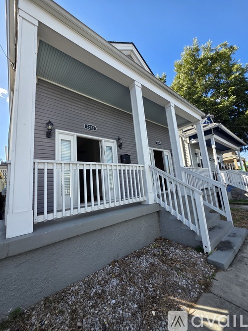 A house with a grey facade and white railings.
