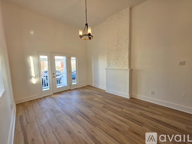 A room with wooden floors and a white brick wall.