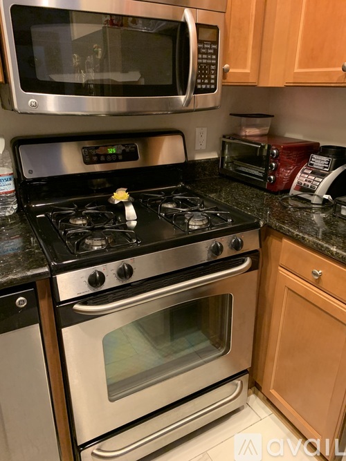 A modern kitchen with a stove top oven and microwave above it.