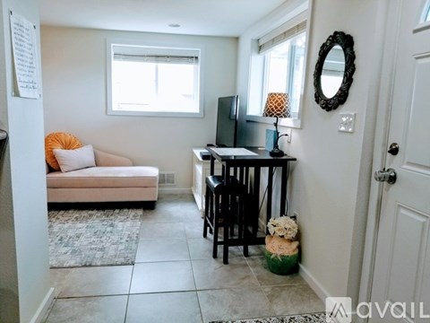 A living room with a couch, a chair, a table with a lamp and a television.