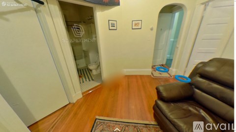 A living room with a brown leather couch and a rug.