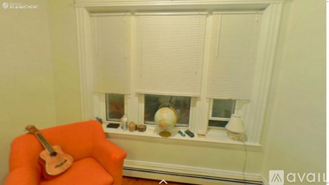 A room with a window, a chair, and a guitar.