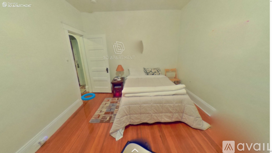 A bedroom with a bed and a rug on the floor.