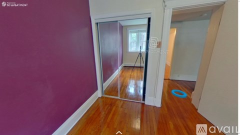 A room with purple walls and a wooden floor.