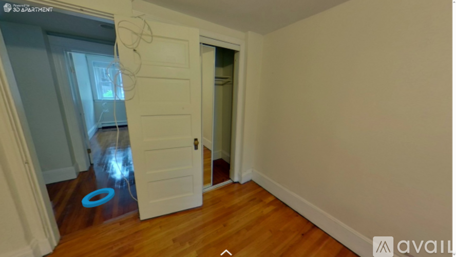 A room with a white door and a blue circle on the floor.