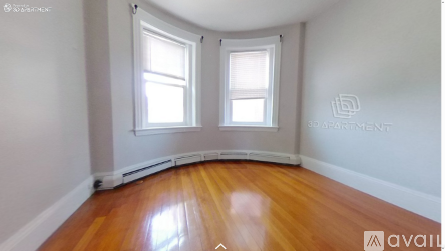 A room with wooden floors and two windows.