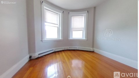 A room with wooden floors and two windows.