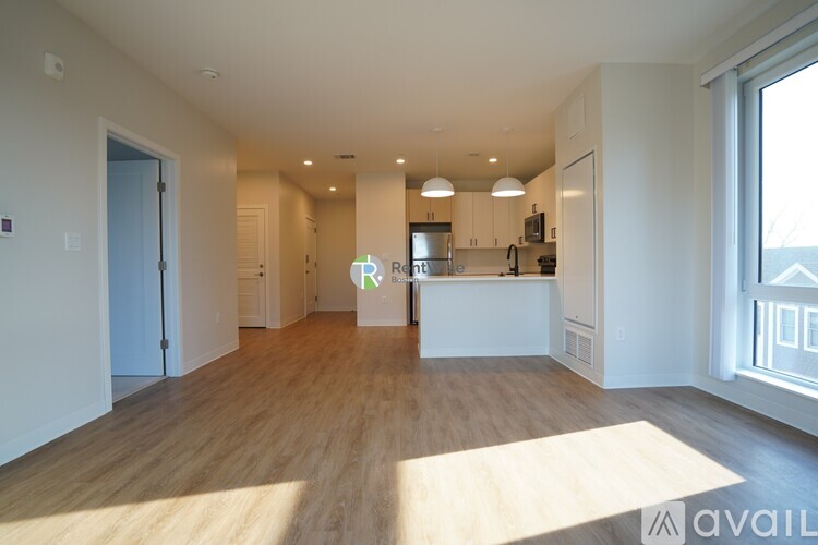 A spacious kitchen with wooden floors and white walls.