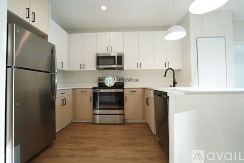A modern kitchen with stainless steel appliances and wooden cabinets.
