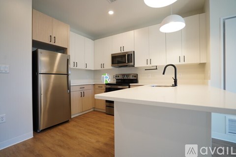 A kitchen with a refrigerator, microwave, and oven.