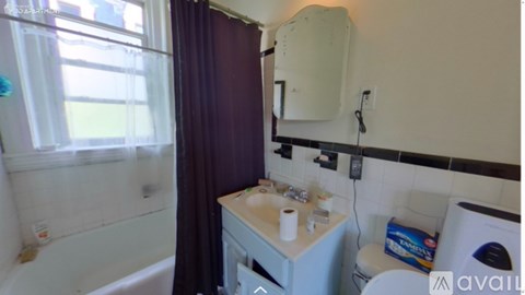 A bathroom with a white sink and a window with curtains.