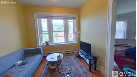 A living room with a grey couch and a round white table.