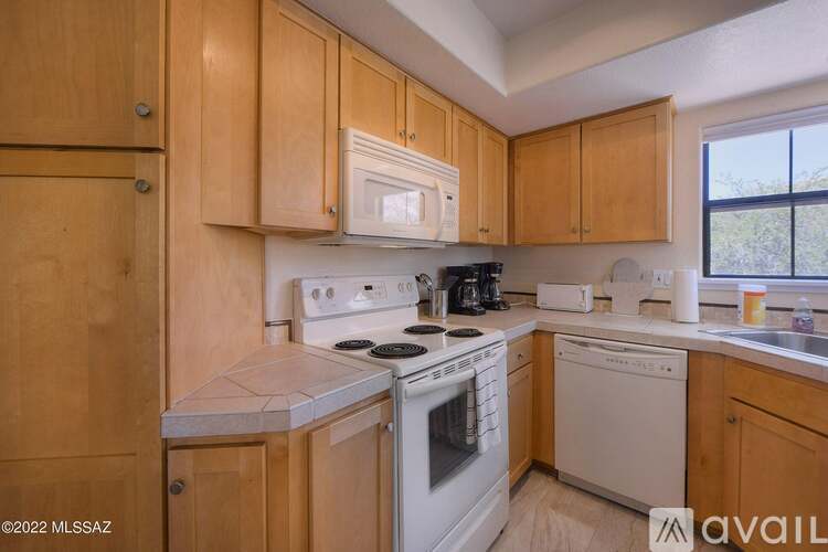 A kitchen with wooden cabinets and white appliances.