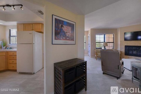 A living room with a television, a couch, and a painting on the wall.