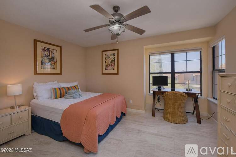 A bedroom with a bed, chair, and two pictures on the wall.